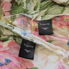 Floral fabric with 'Auguste' brand labels on a floral background