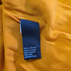 Close-up of a label on a yellow fabric garment with text.