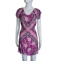 Mannequin wearing a vibrant, patterned dress against a plain background