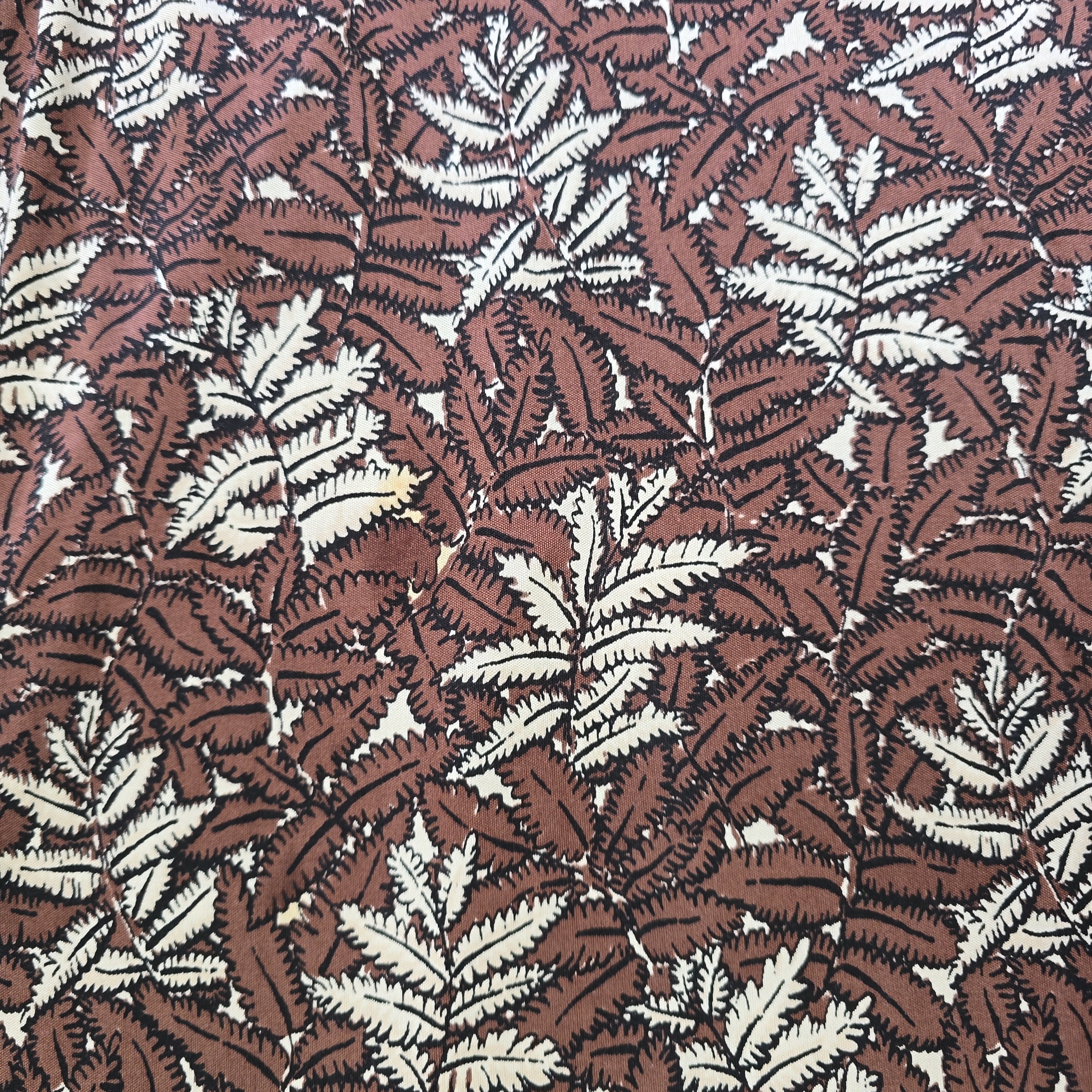 Pattern of brown and beige leaves on a fabric background