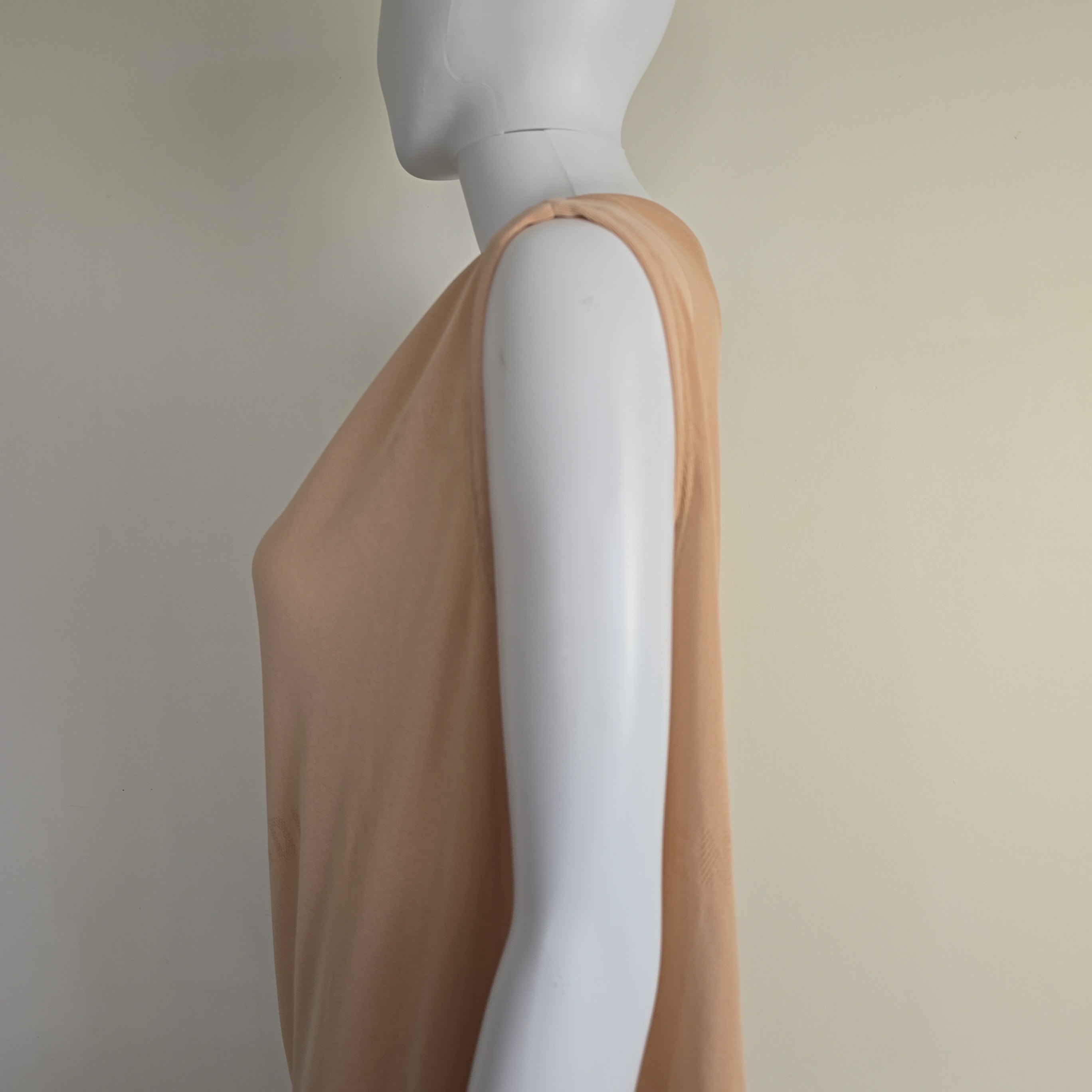 Mannequin wearing a beige top on a plain background