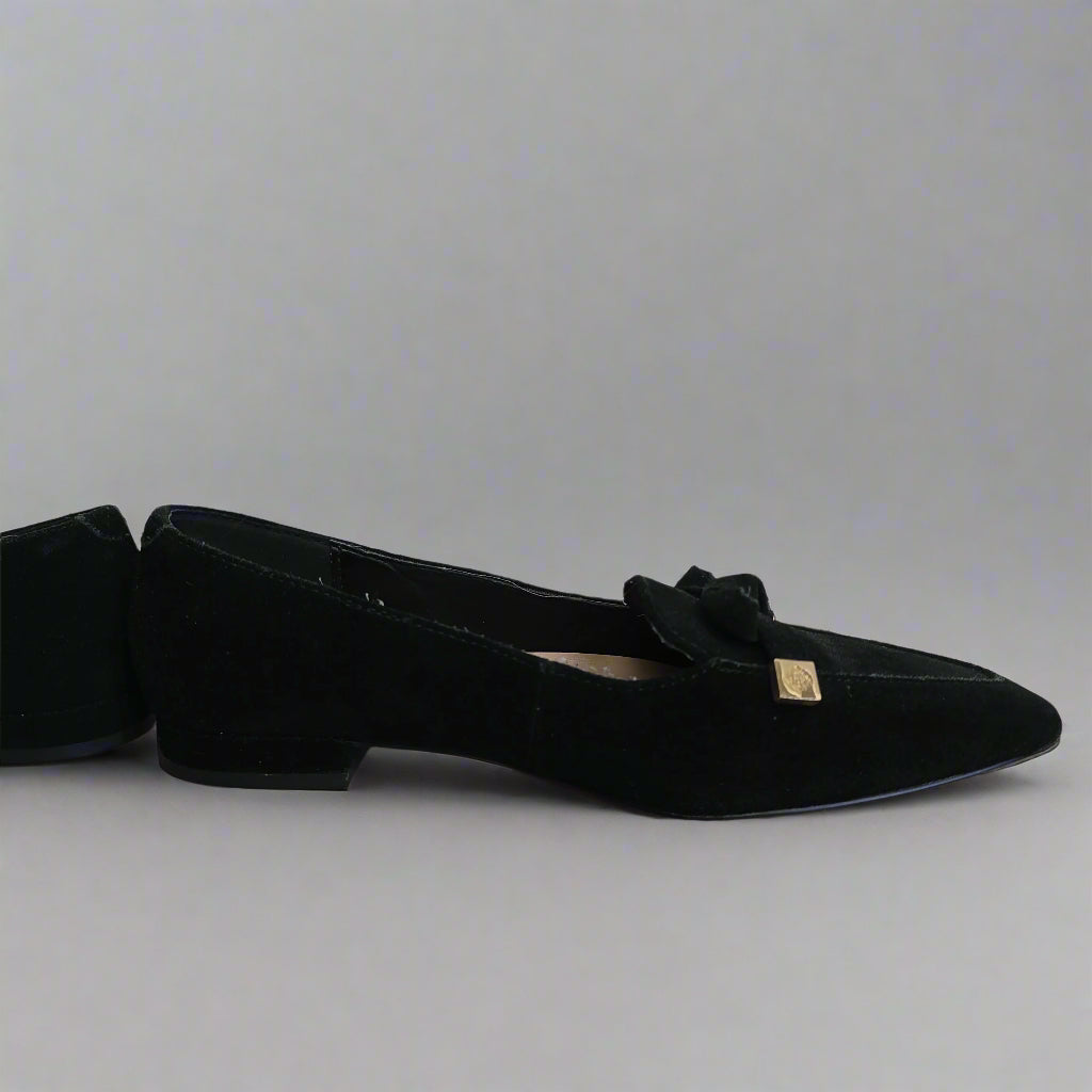 Black flat shoe with a bow on a tiled floor