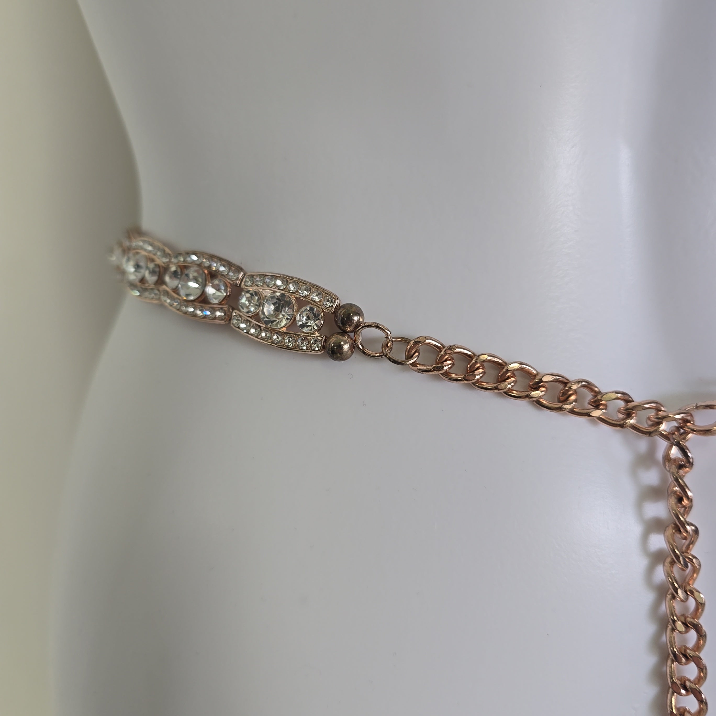 Rose gold belt on a mannequin against a white background