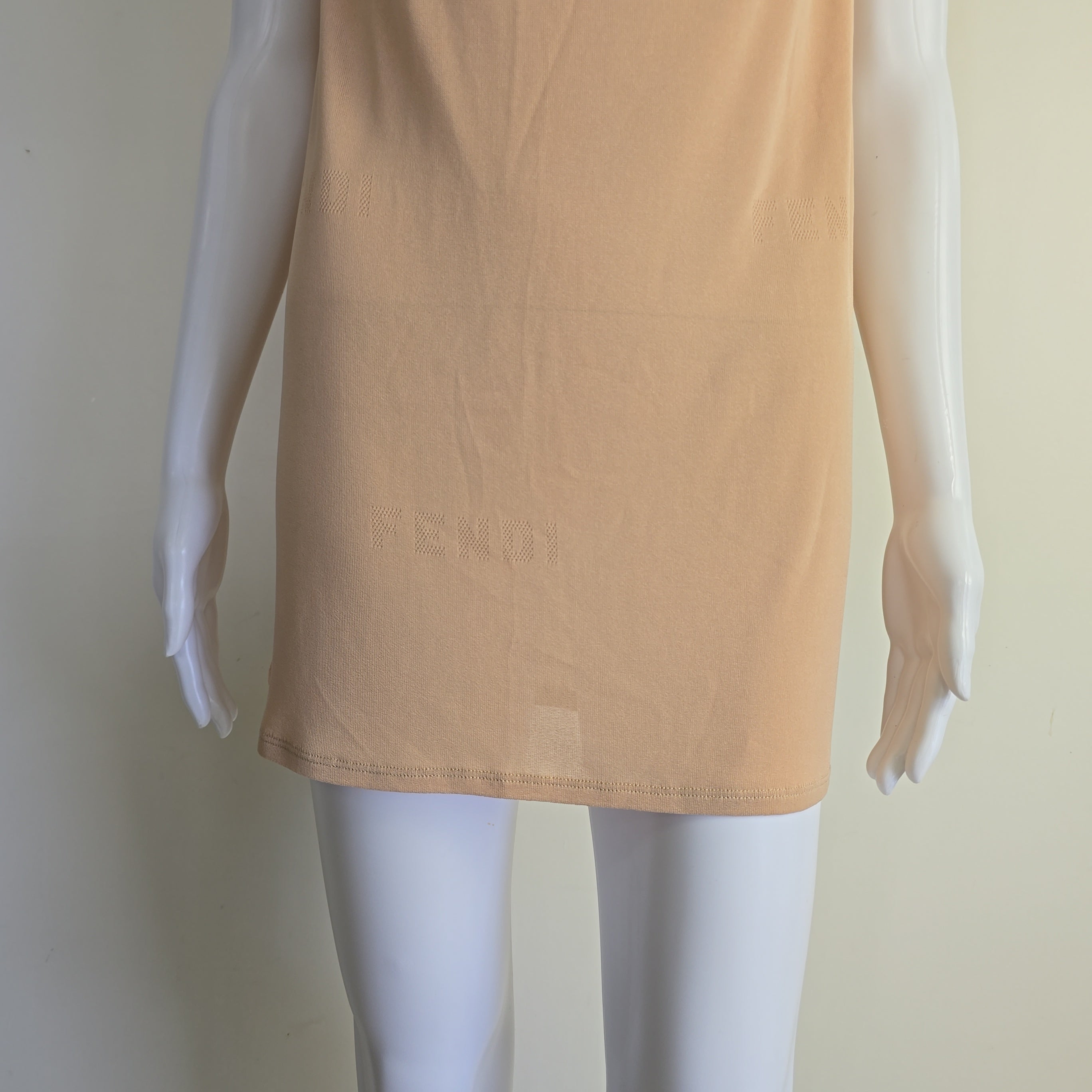 Mannequin wearing a beige top on a plain background