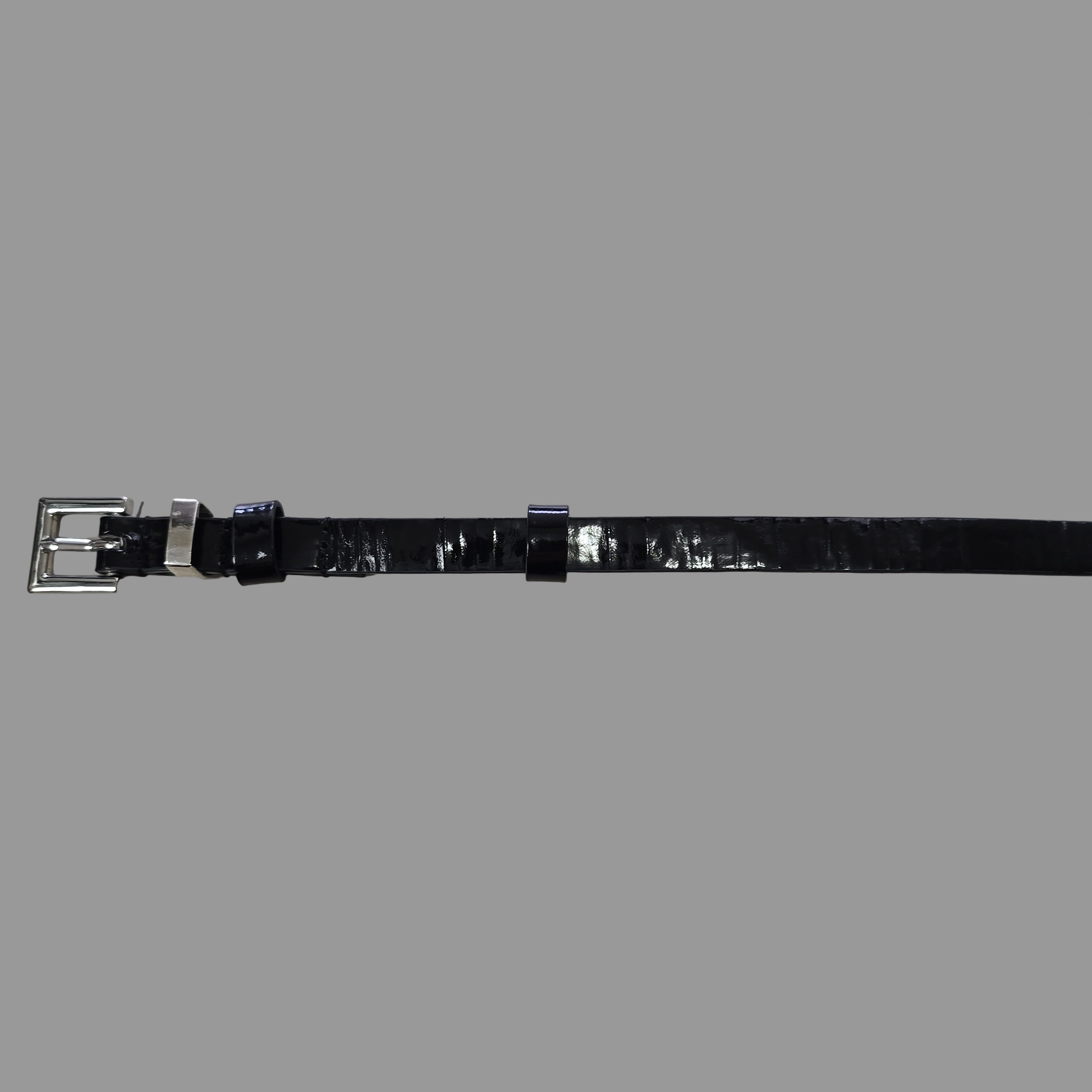 Black leather belt with silver buckle on a light gray background