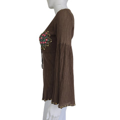 Brown top with floral embellishments on a mannequin against a plain background