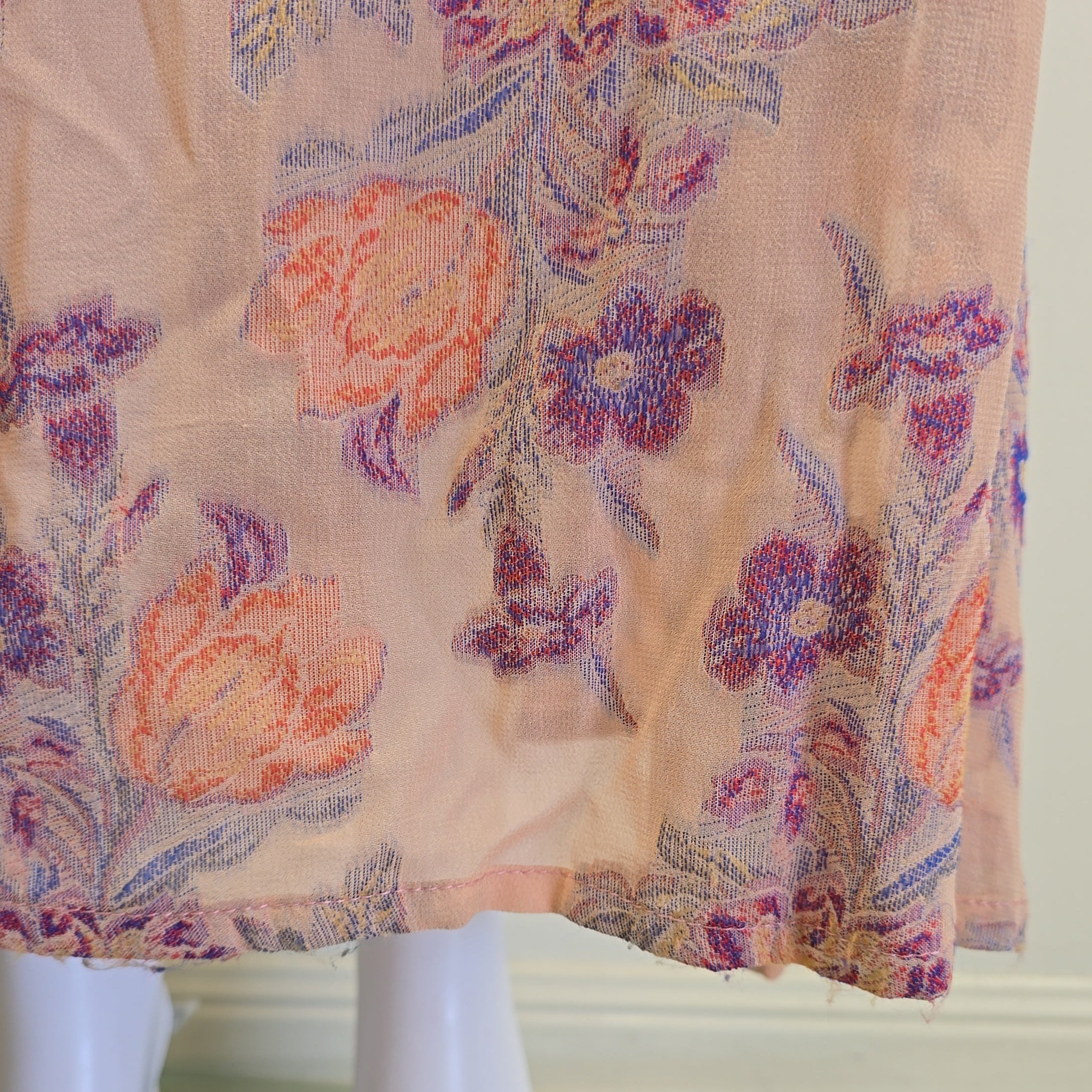 Floral-patterned fabric draped over a mannequin against a neutral background