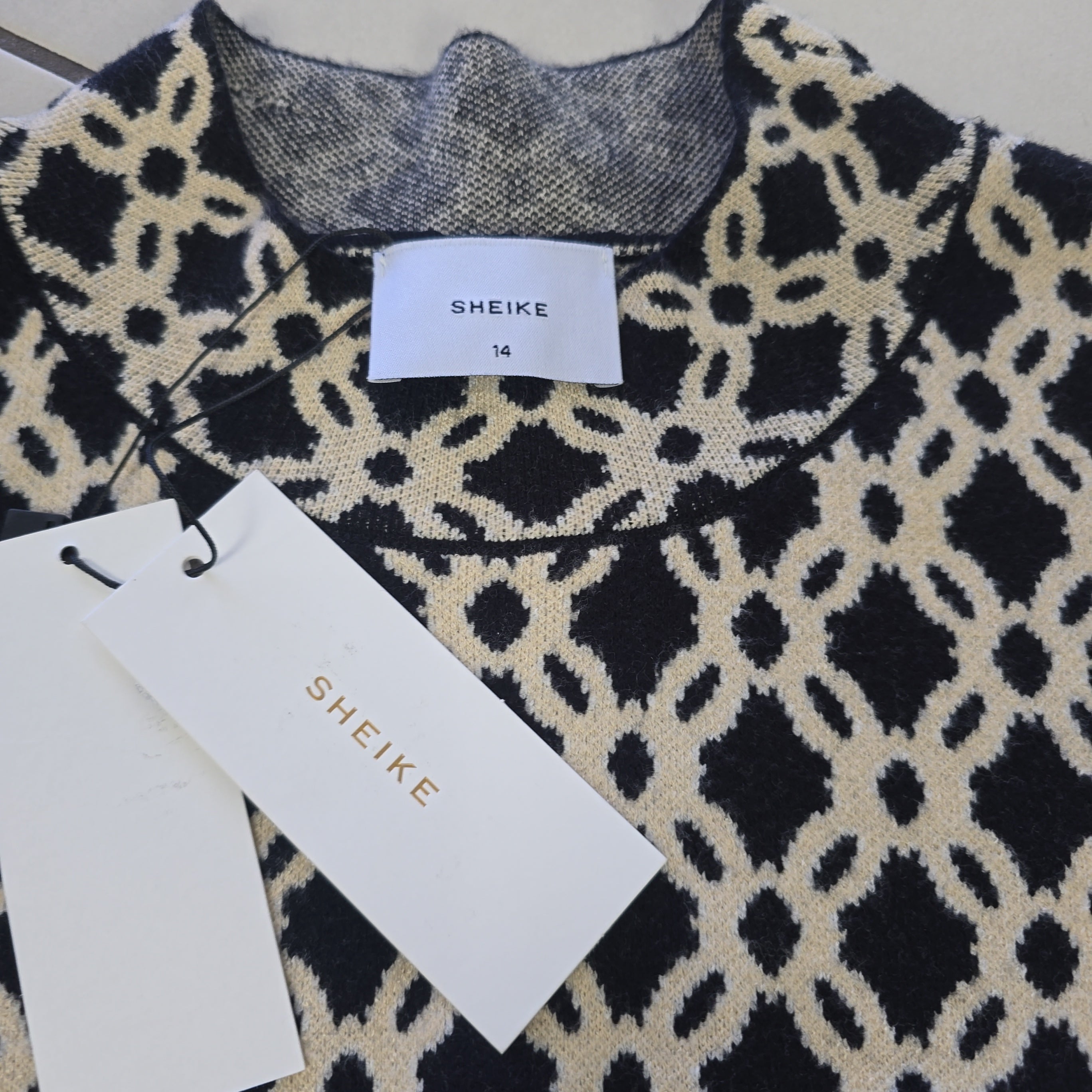 Patterned fabric with SHEIKE branding on tags