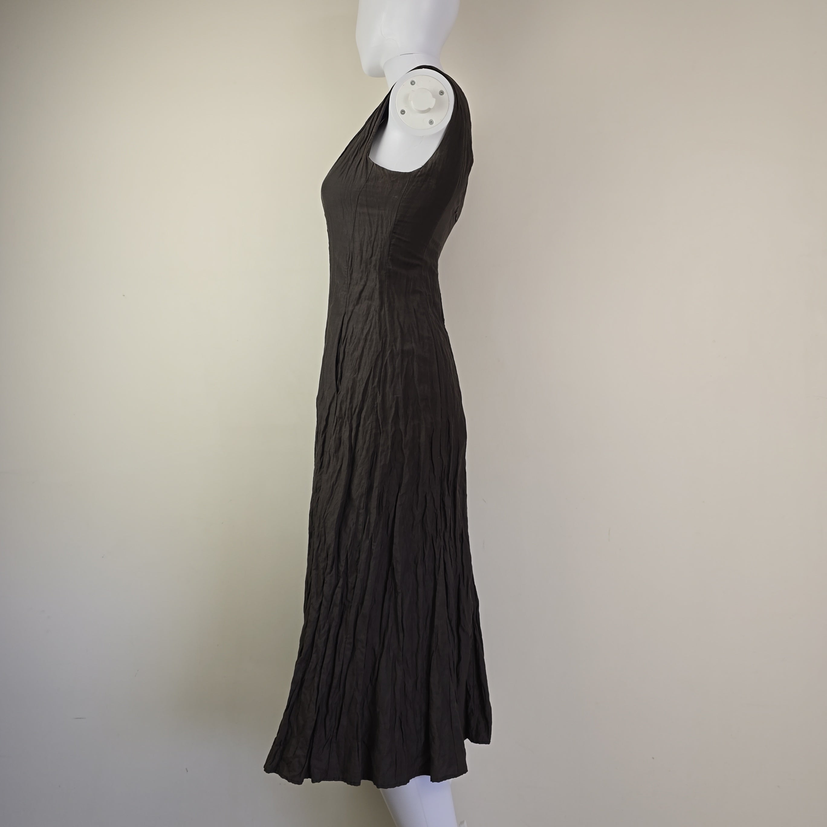 Black dress on a mannequin against a plain background