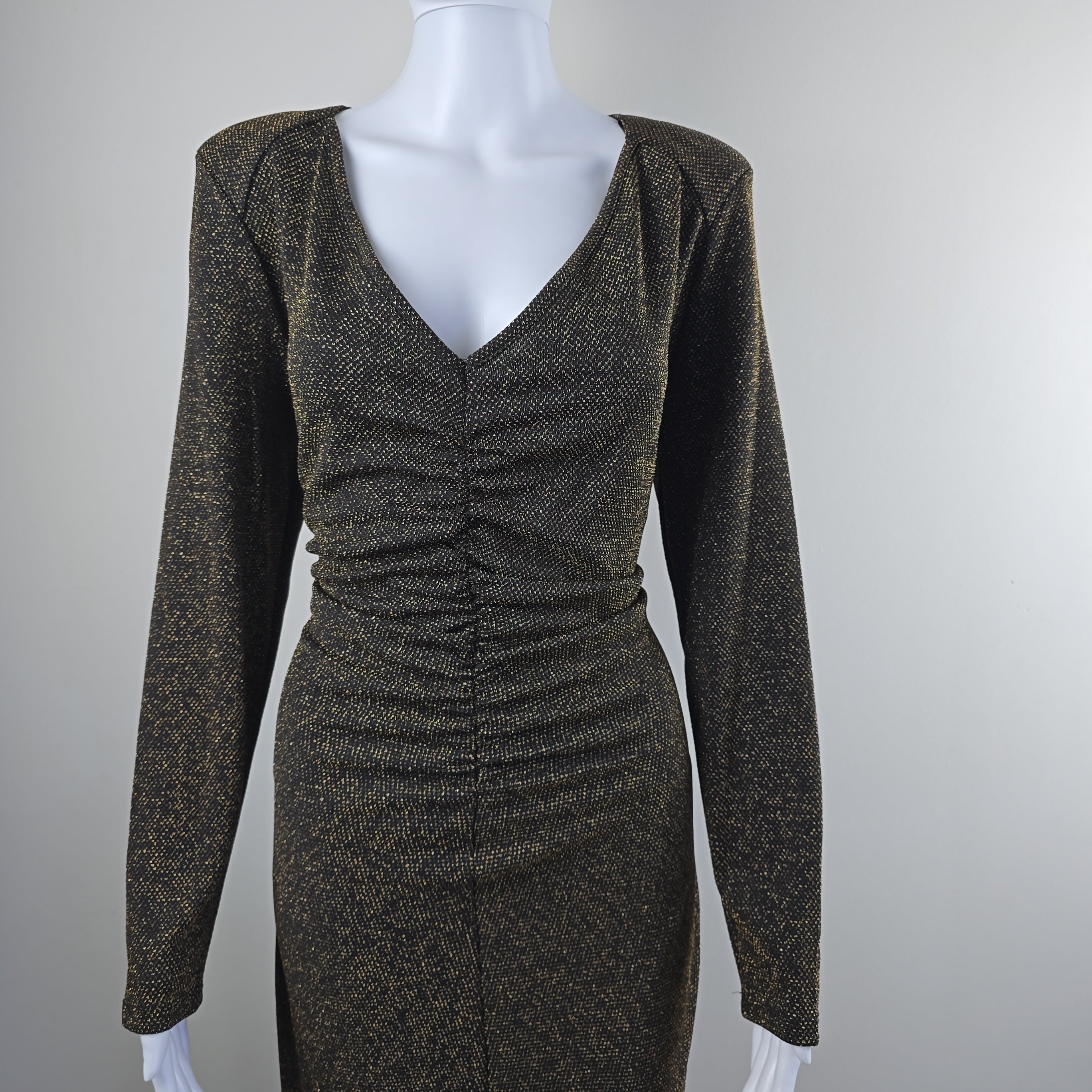 Black and gold textured dress on a mannequin against a light gray background