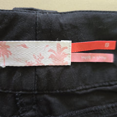 Close-up of a black garment with a pink and white tag featuring a star pattern.