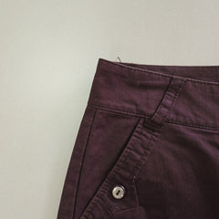 Close-up of a purple garment with a button on a light gray background