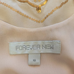 Close-up of a 'Forever New' label on a garment with gold embroidery.