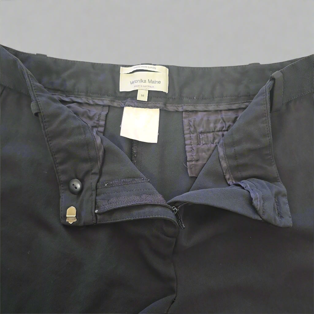 Dark Pants with a brand label on a beige background