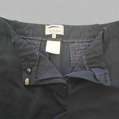 Dark Pants with a brand label on a beige background