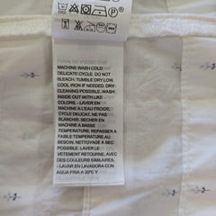 Clothing label with text and symbols on a white fabric background