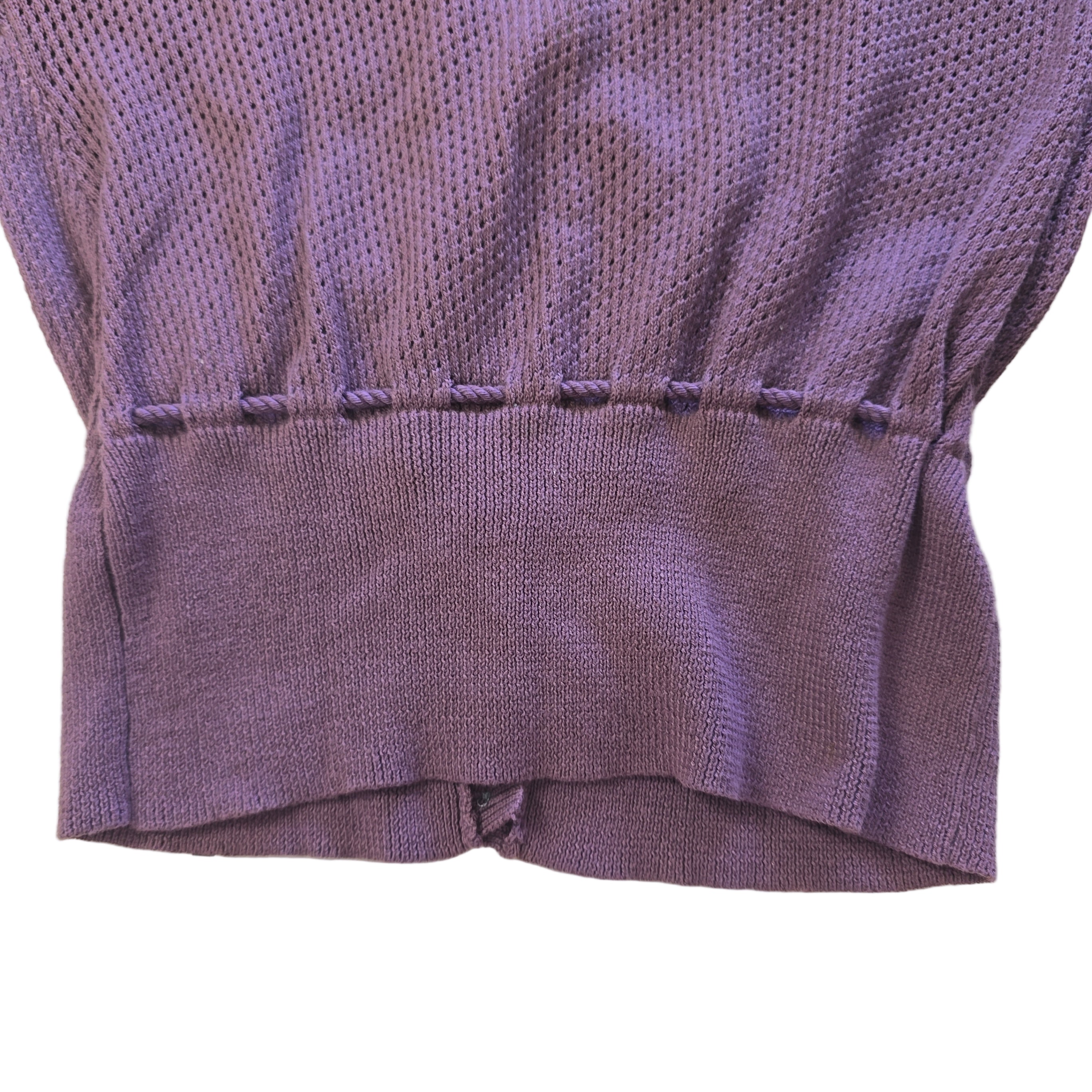 Close-up of a purple textured fabric garment on a light background