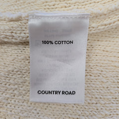 Label on a textured fabric surface indicating 100% cotton and 'Country Road' brand.