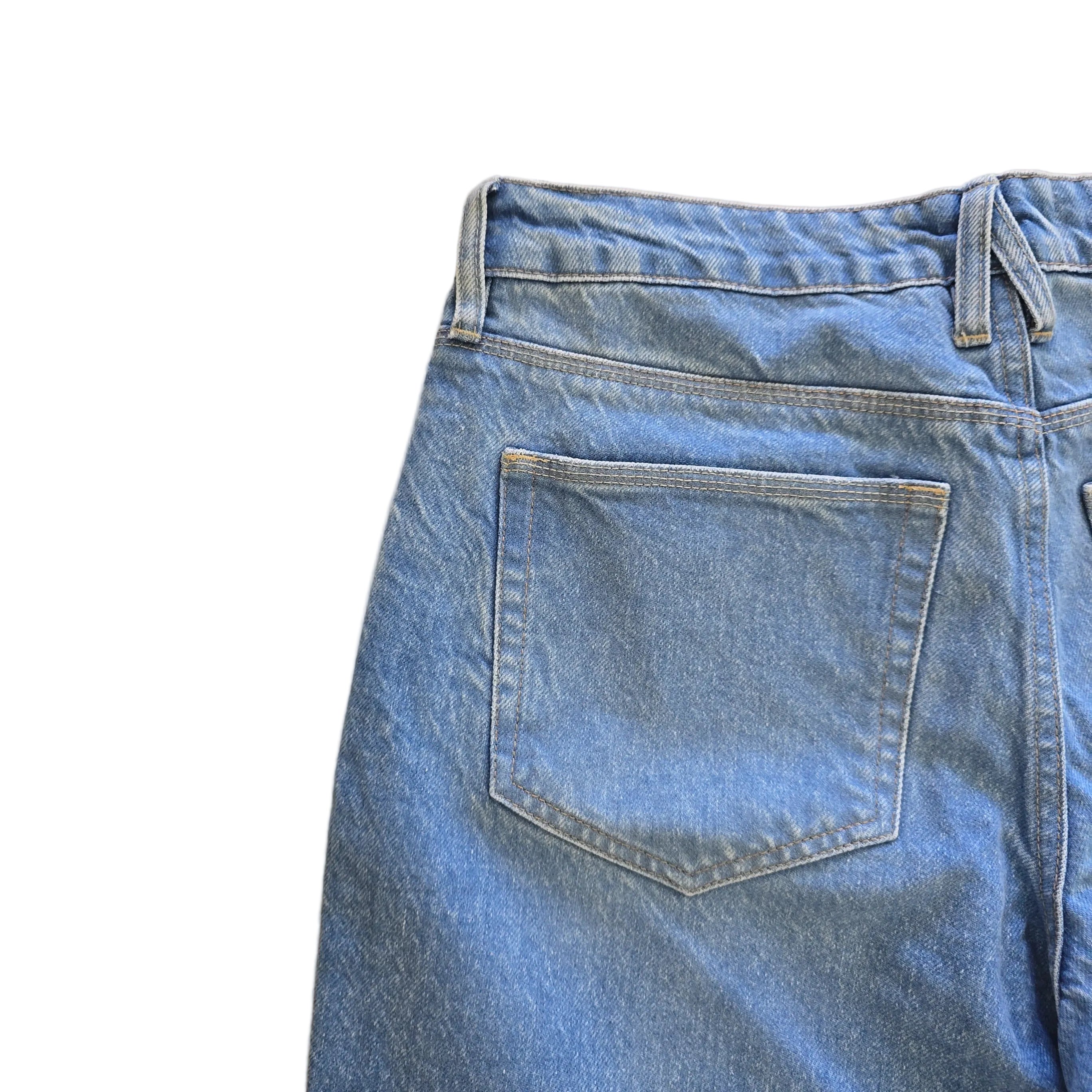 Close-up of blue denim jeans on a beige surface