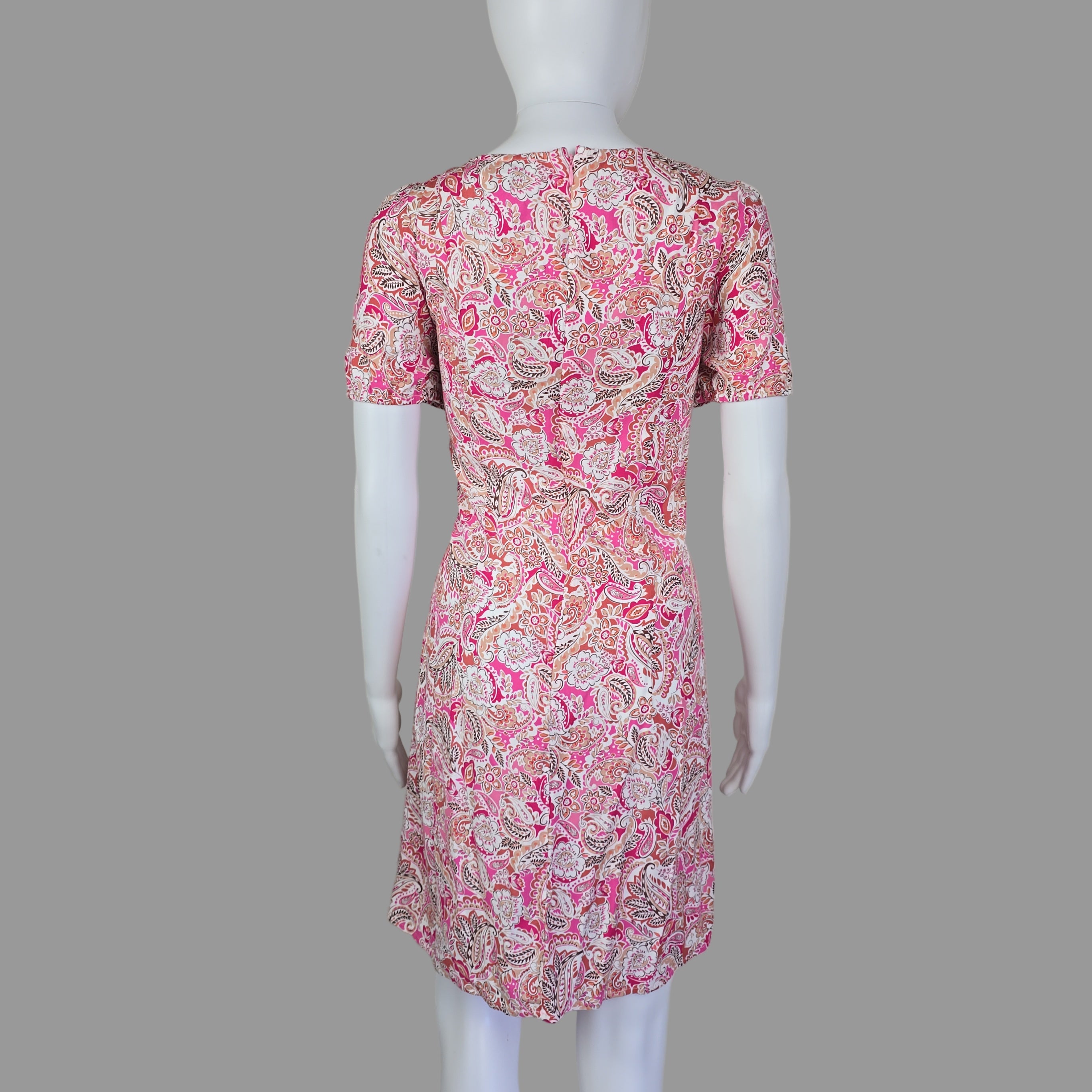 Mannequin wearing a pink floral dress on a white background