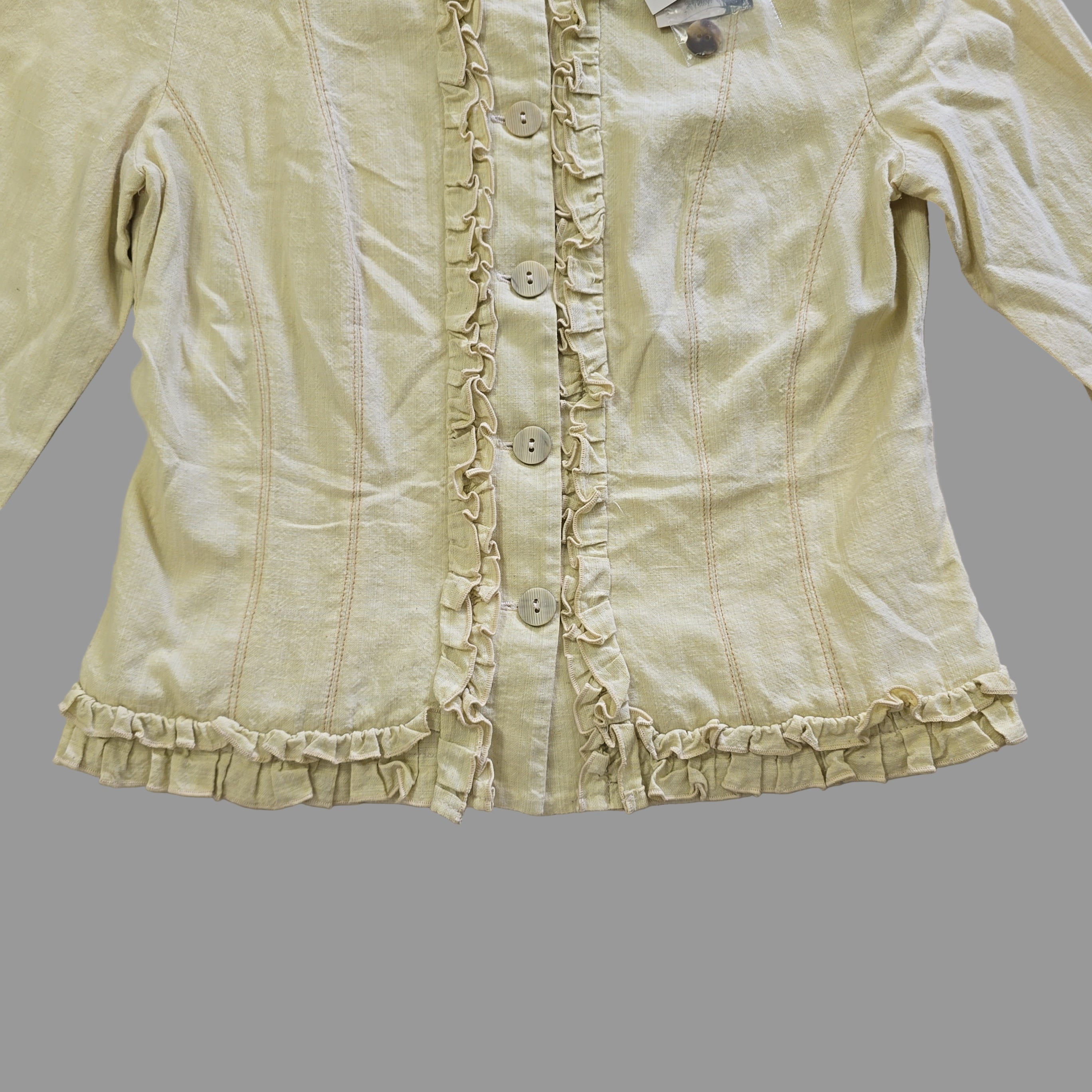 Light yellow jacket with frill details on a light background