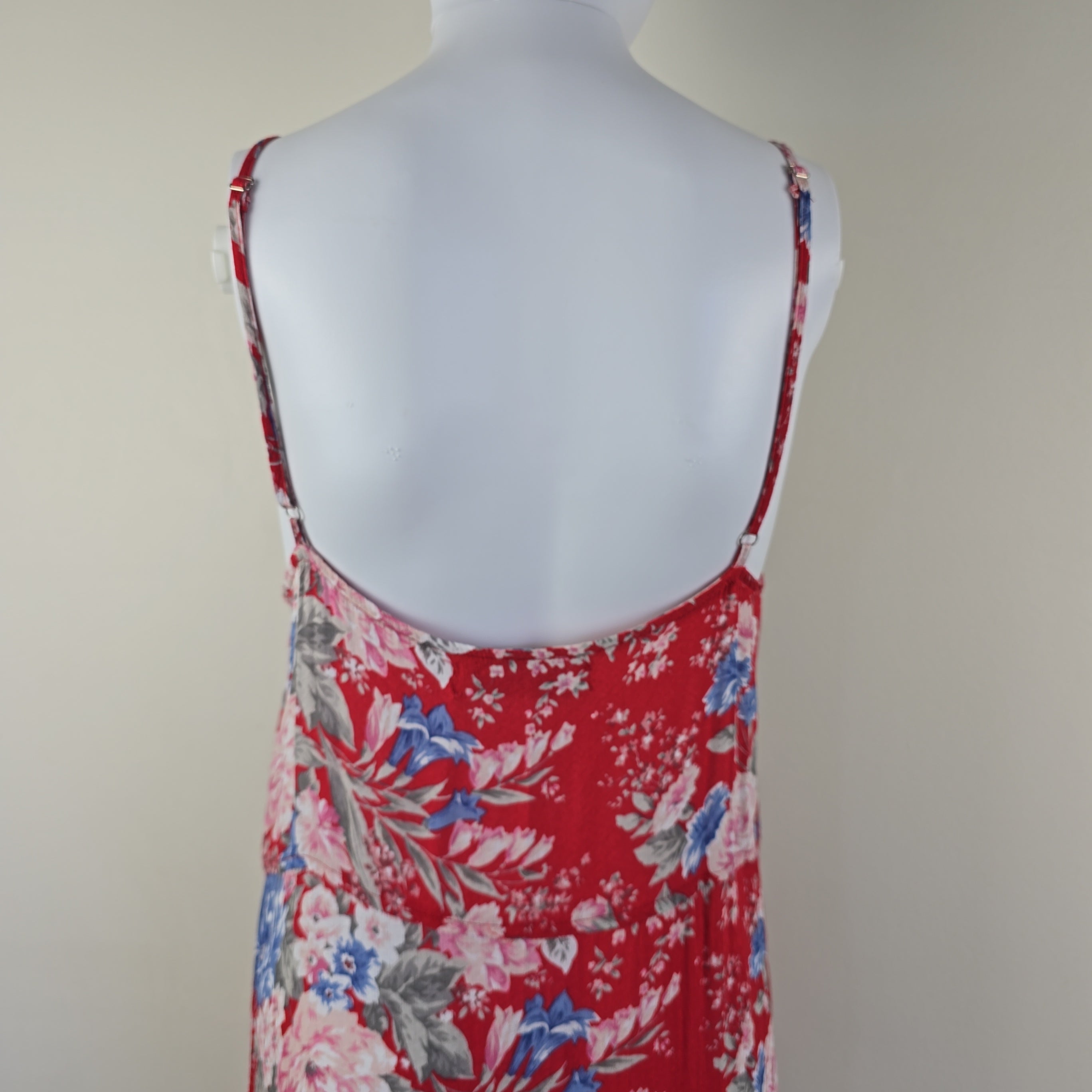 Red floral top on a mannequin against a plain background