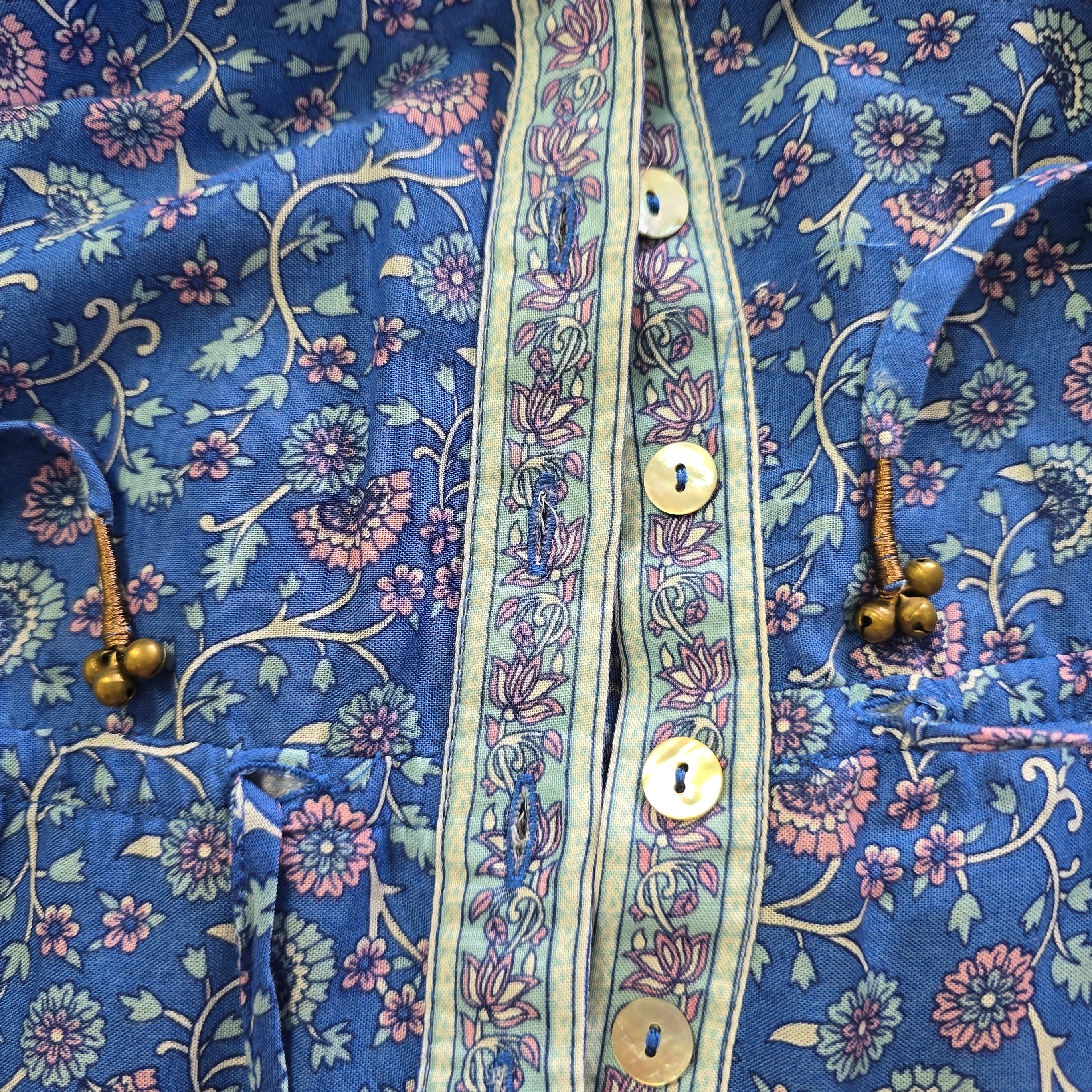 Close-up of a blue floral-patterned fabric with buttons.