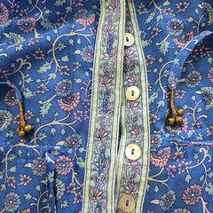 Close-up of a blue floral-patterned fabric with buttons.