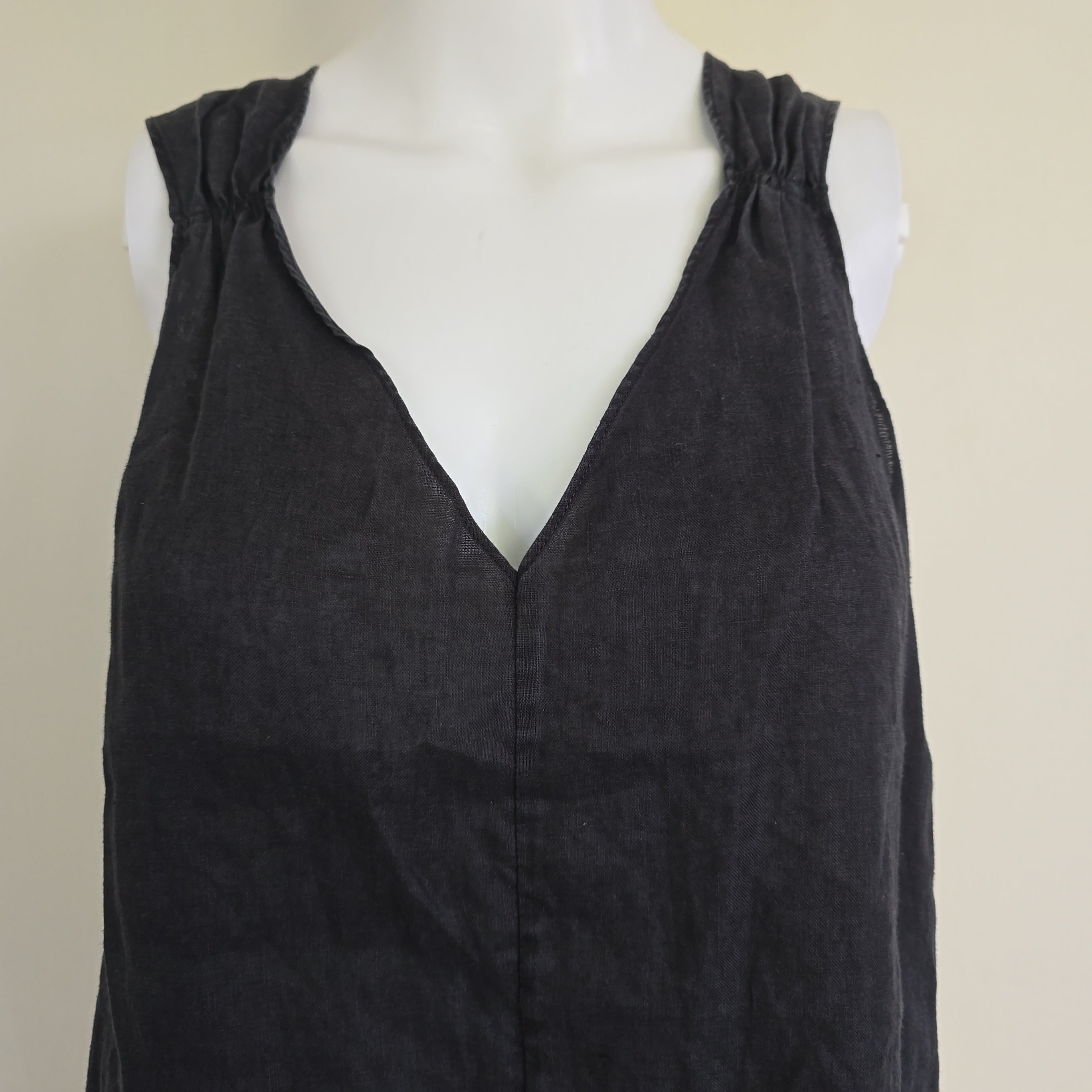 Black top on a mannequin against a beige background