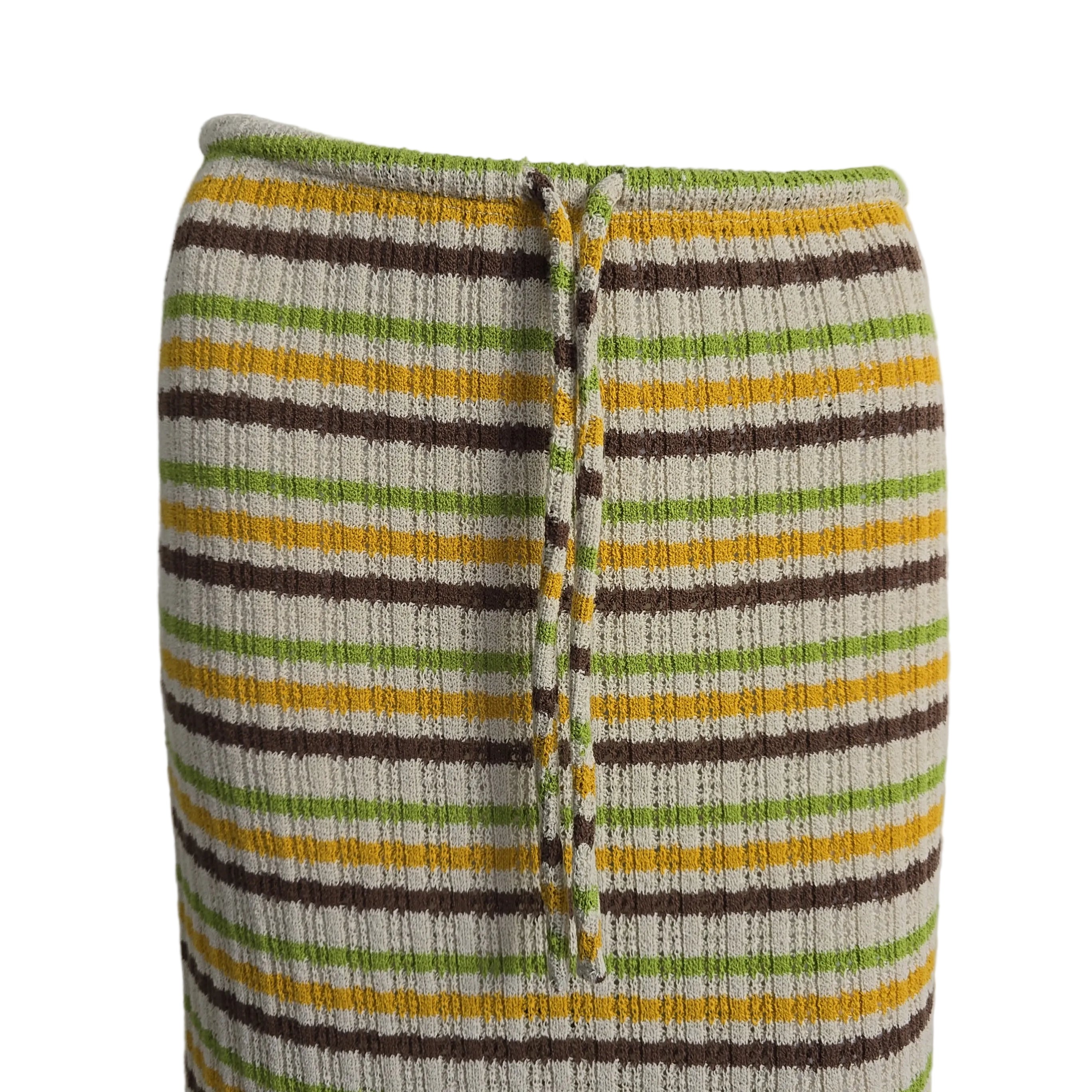 Striped fabric with green, yellow, and brown colors on a mannequin.