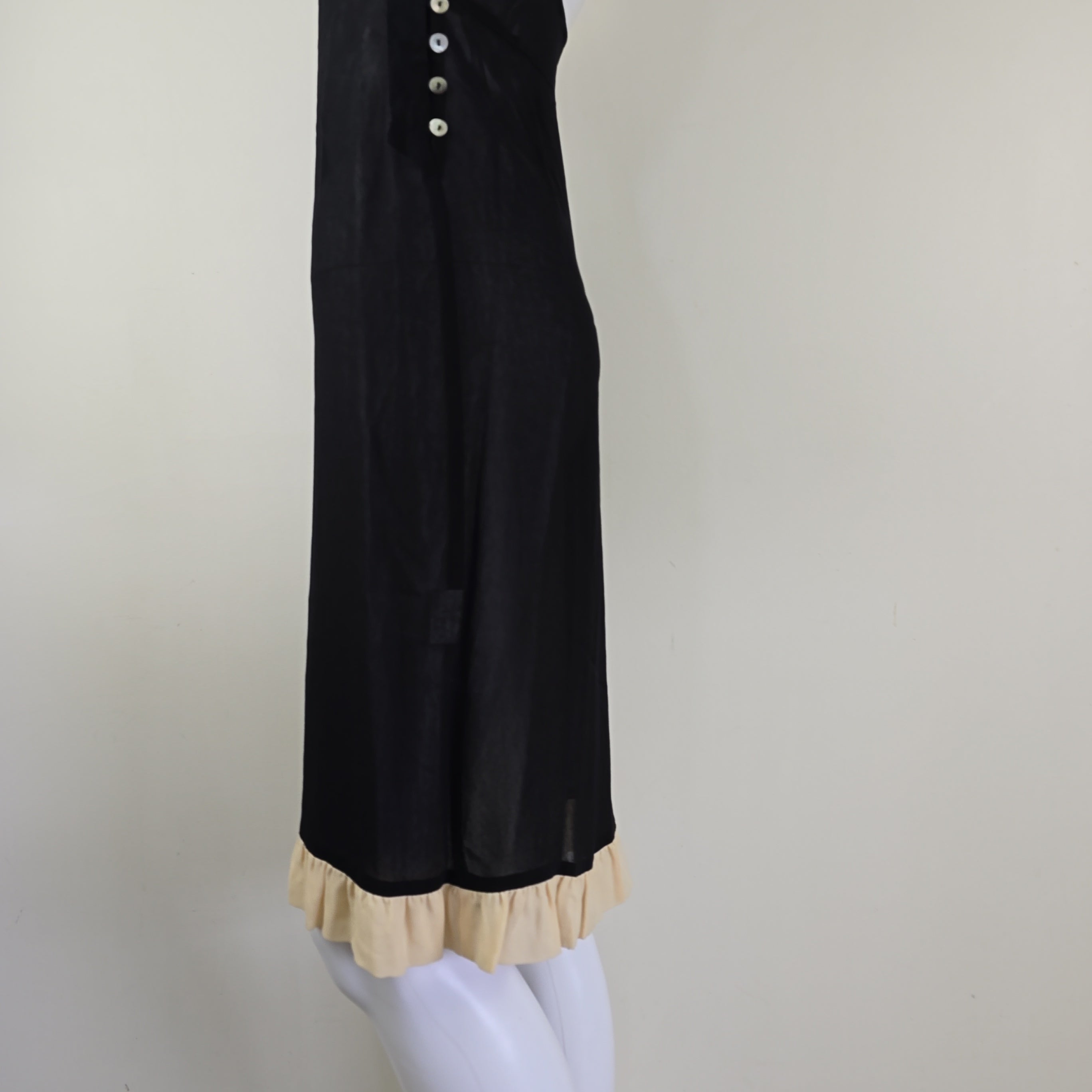 Black dress with beige lining on a light background