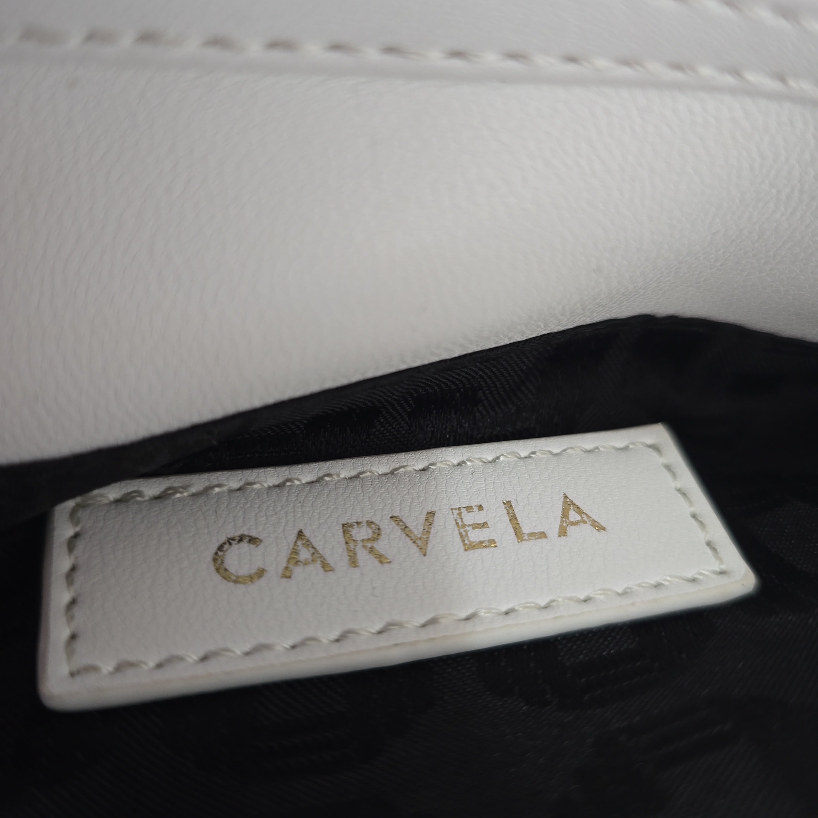 Close-up of a 'Carvela' label on a product with a white and black background.