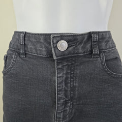 Close-up of a gray denim skirt with a button on a white background