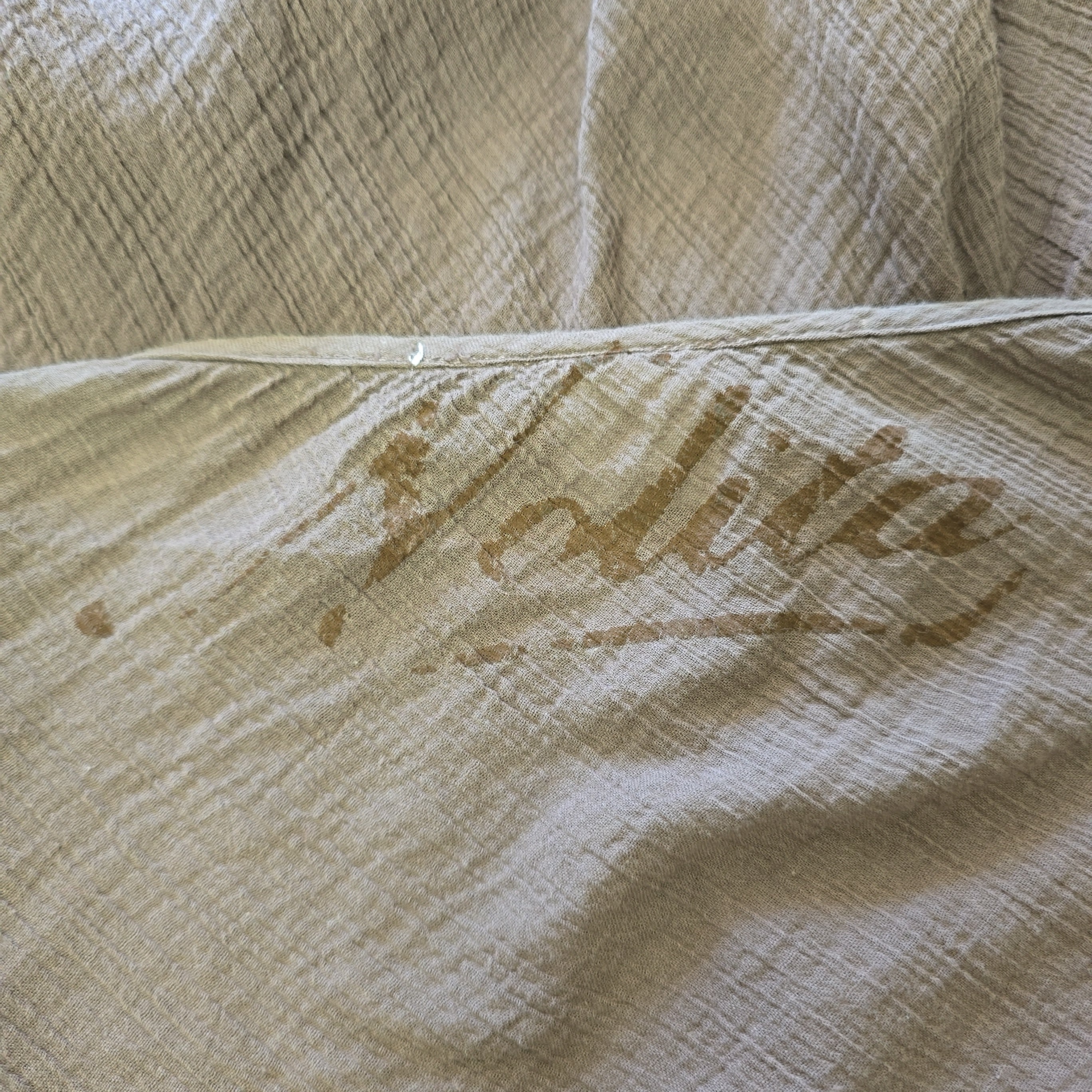 Close-up of a brown fabric with 'Nolita' text printed on it