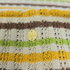 Striped fabric with a gold button featuring the brand 'Billabong' on a textured background.