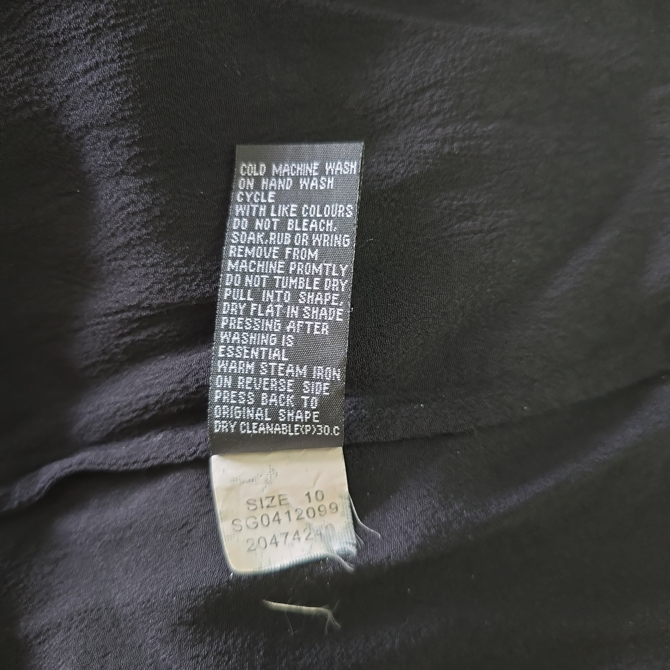 Clothing tag on a dark fabric background