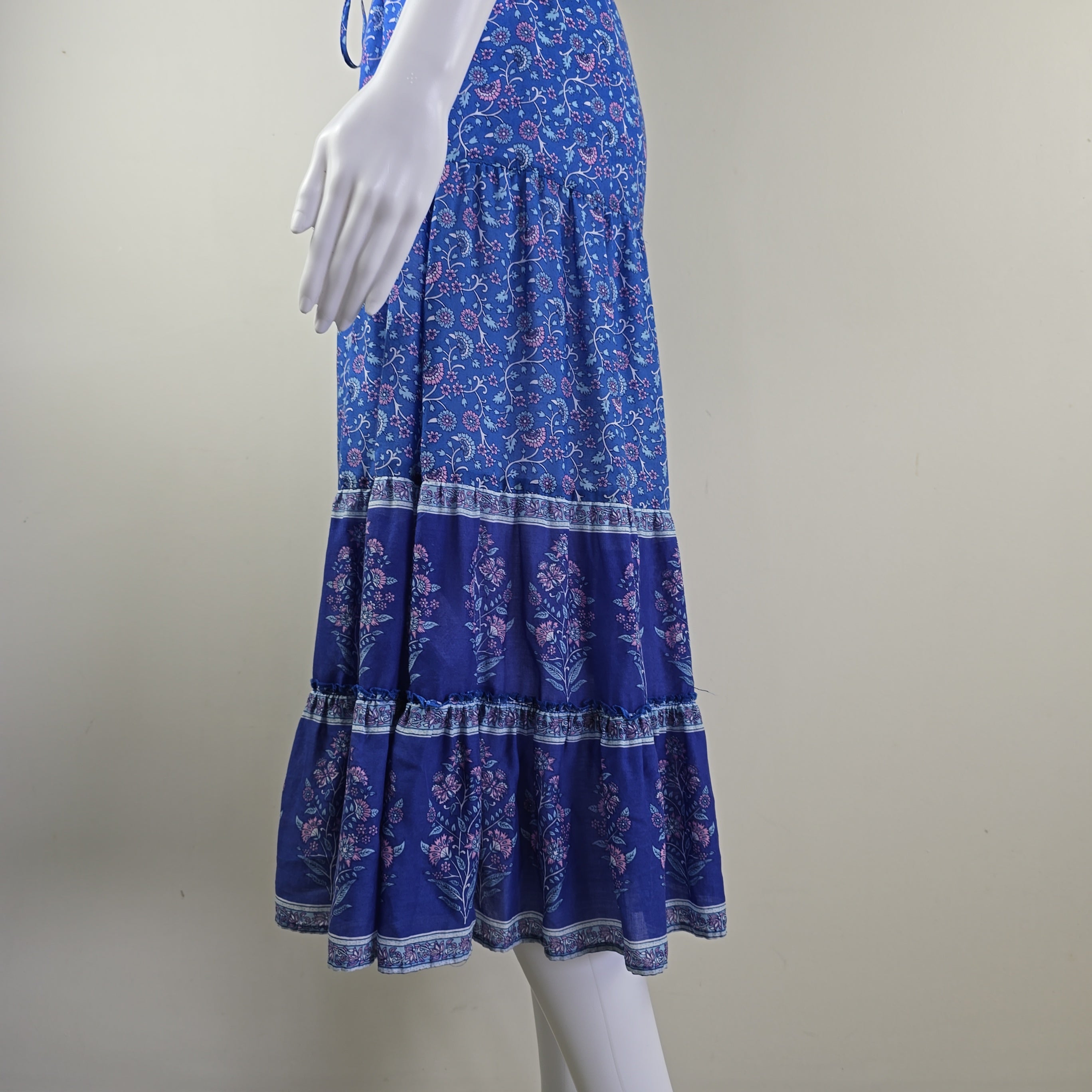 Blue patterned fabric and a mannequin arm against a plain background