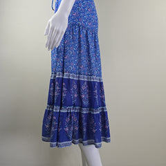 Blue patterned fabric and a mannequin arm against a plain background
