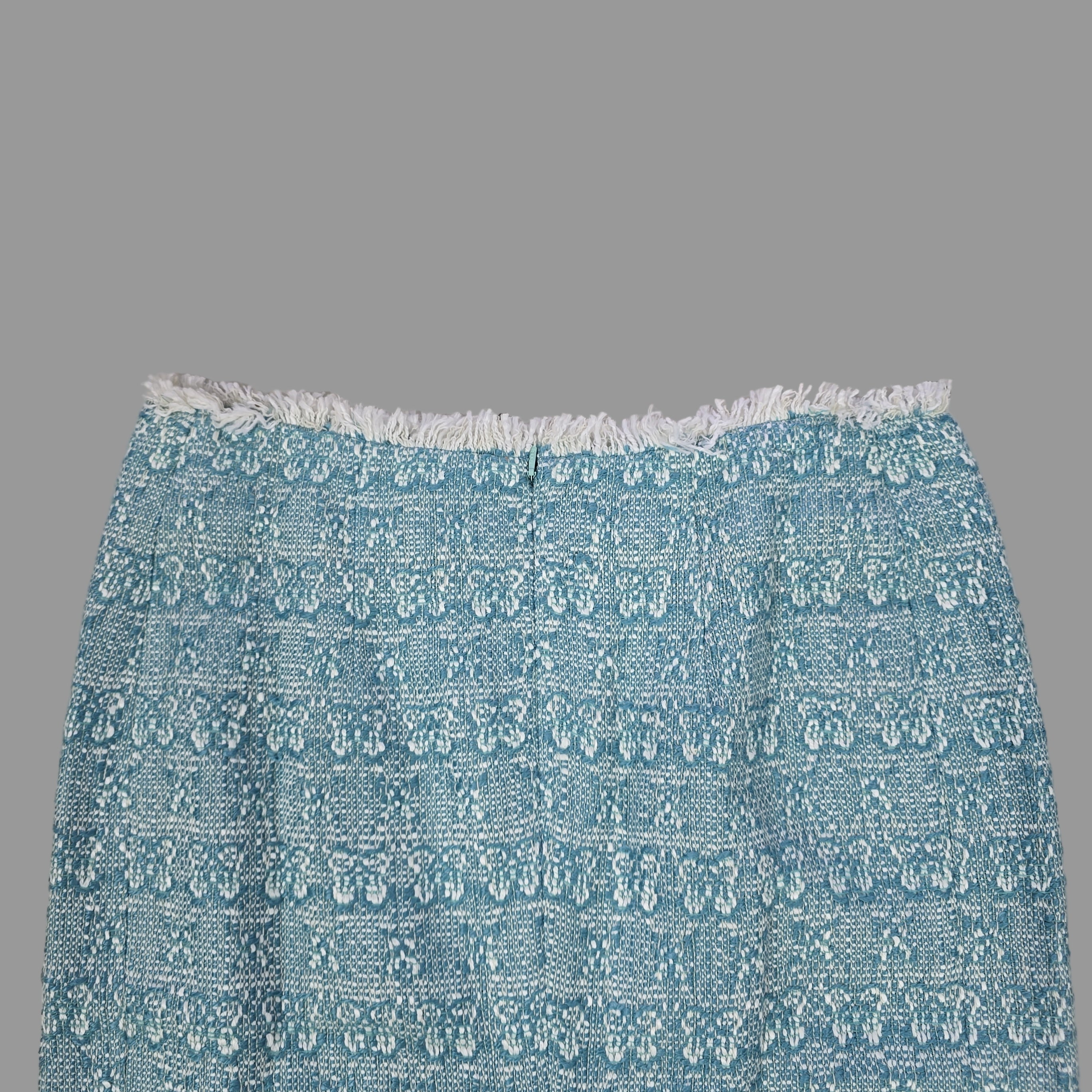 Blue textured skirt with white fringe on a tiled floor