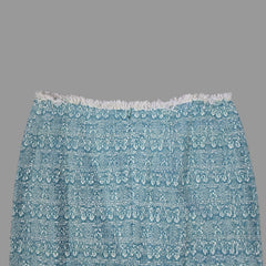 Blue textured skirt with white fringe on a tiled floor
