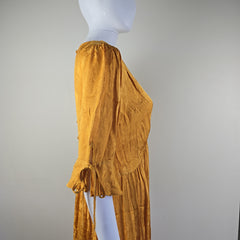 Mustard yellow dress on a mannequin against a plain background