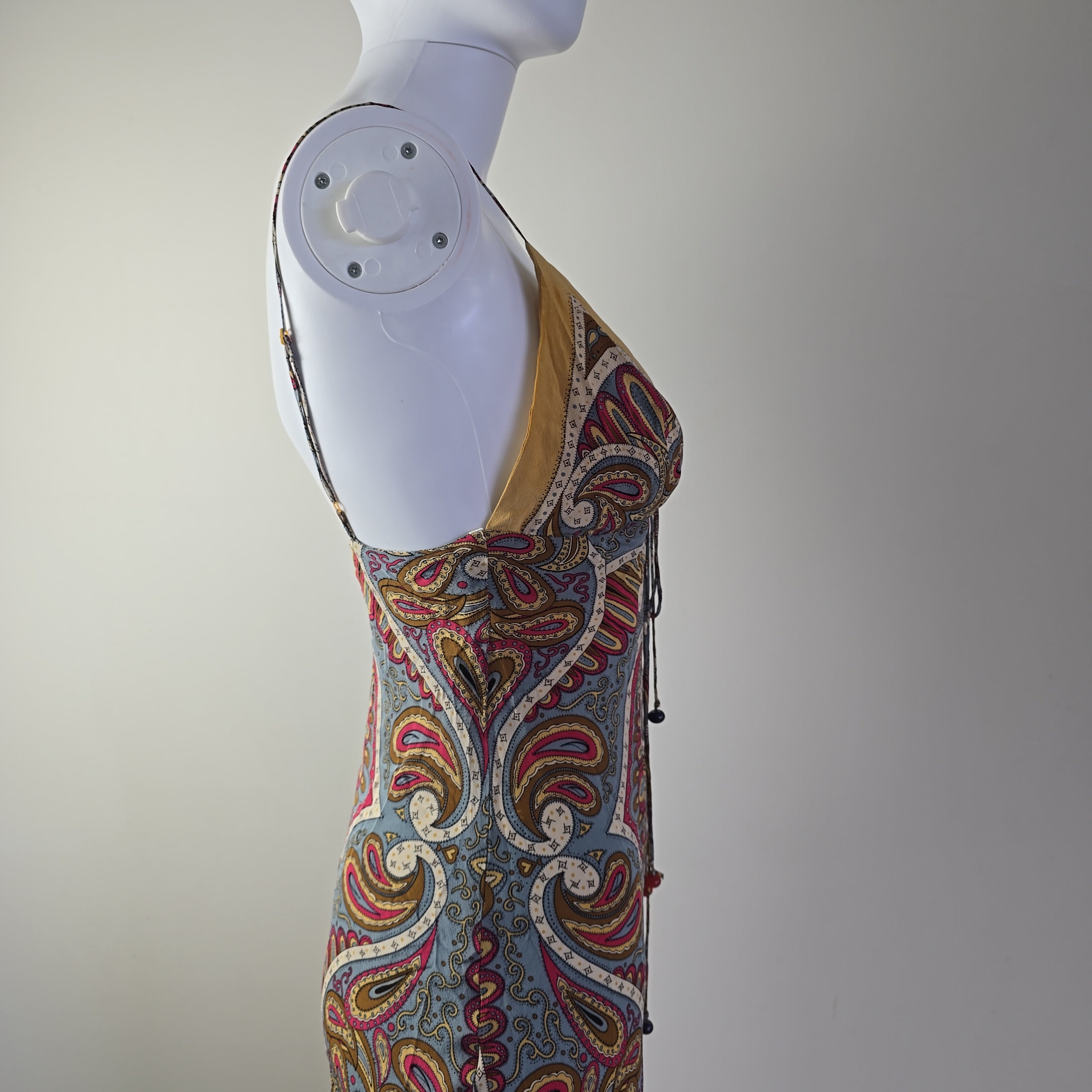 Decorative fabric with intricate patterns on a mannequin arm against a plain background