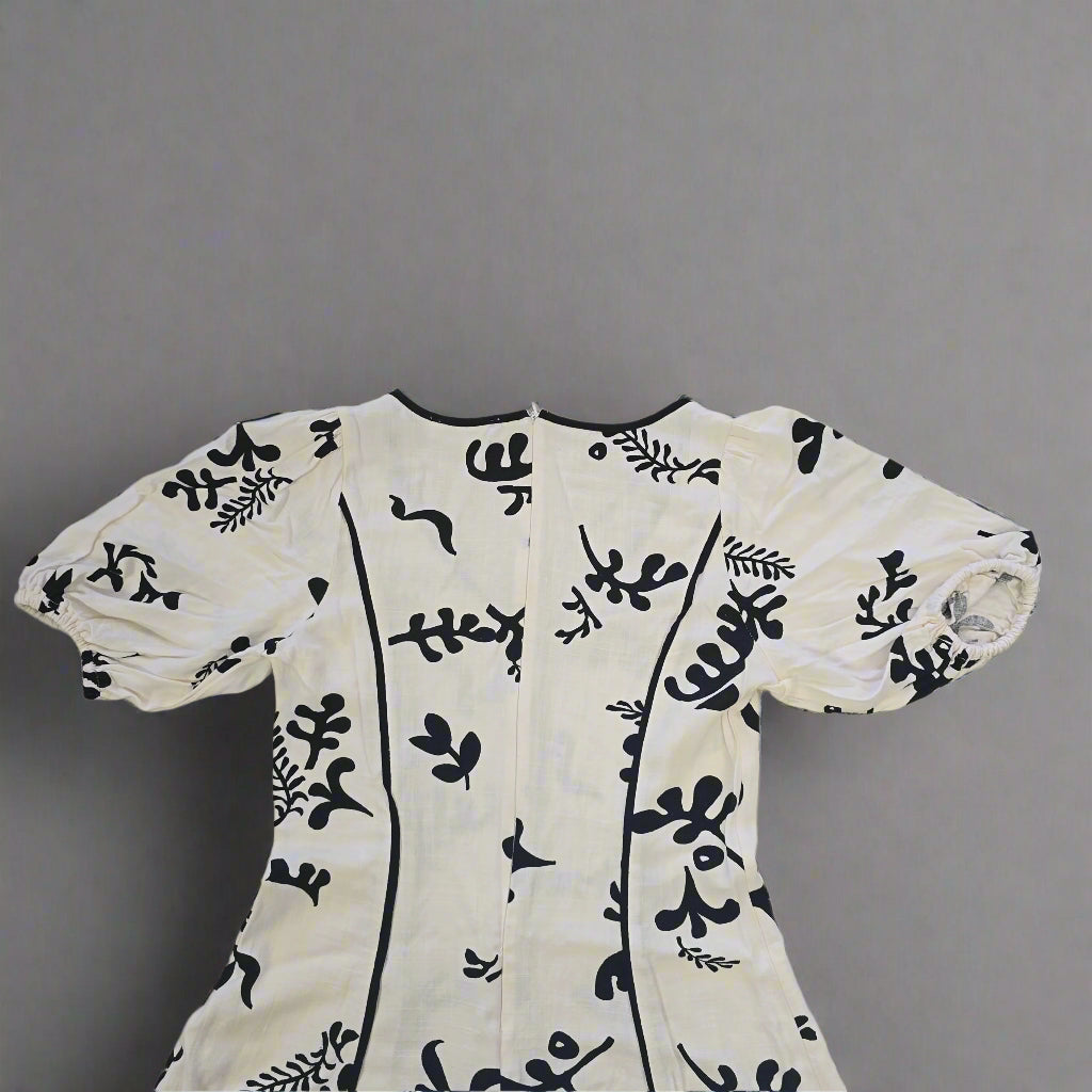 White garment with black floral patterns on a tiled floor