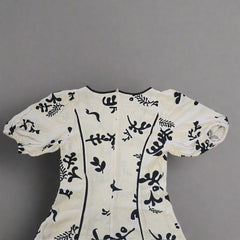 White garment with black floral patterns on a tiled floor