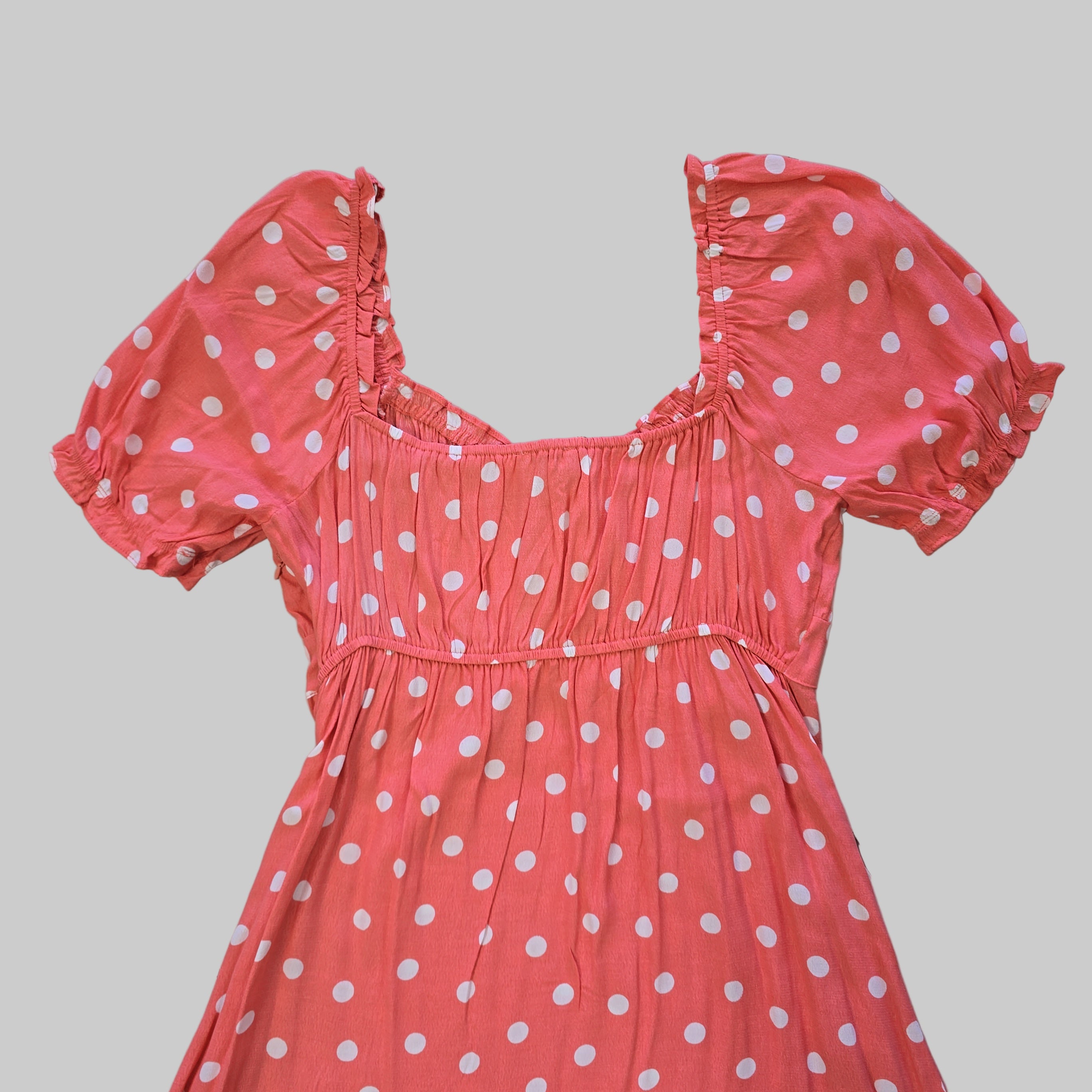 Pink polka dot dress on a tiled floor