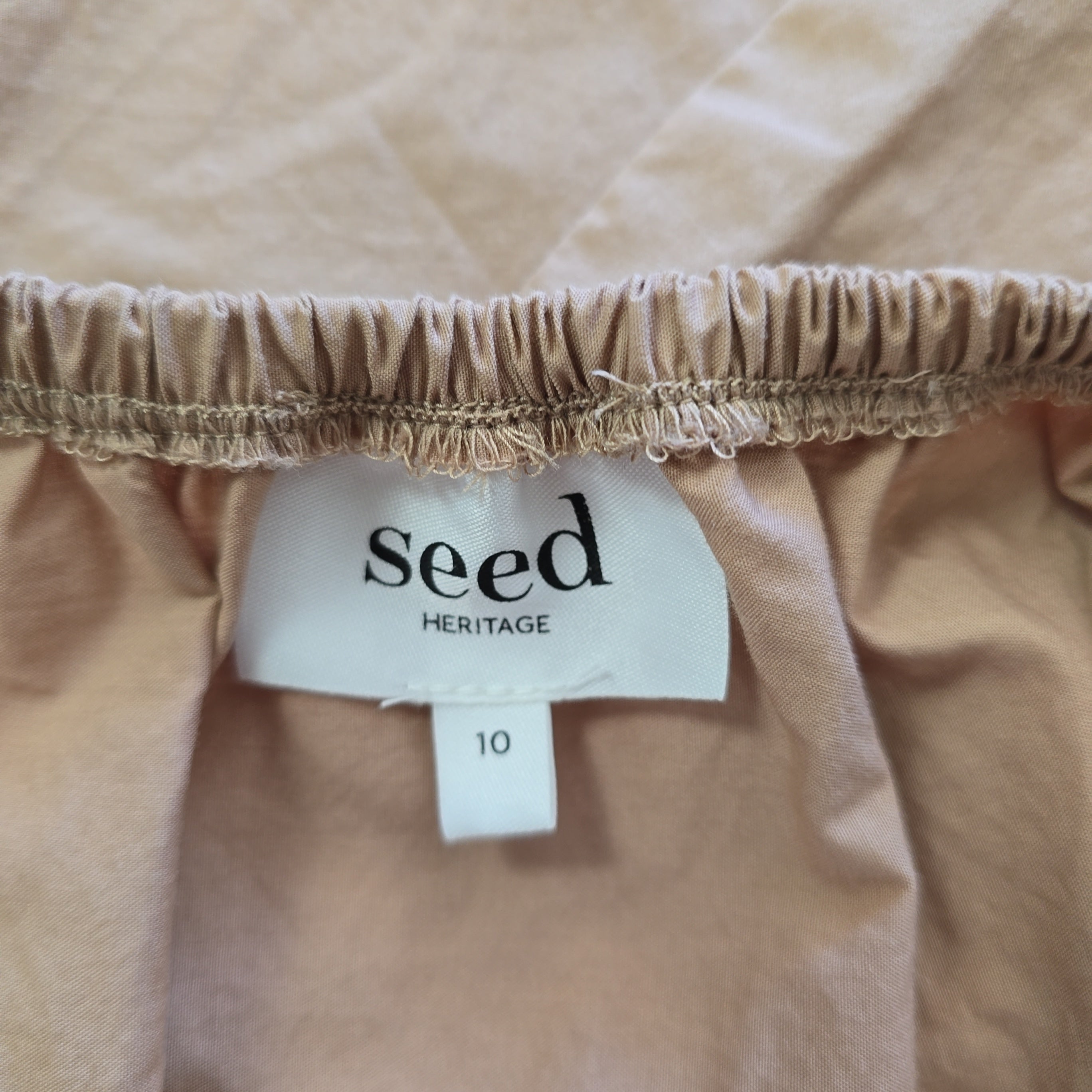 Close-up of a beige fabric with a 'seed Heritage' label.