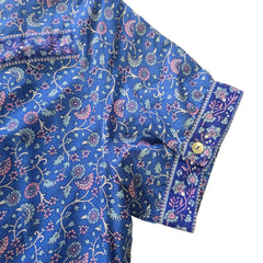 Blue floral-patterned fabric with a button on a beige background