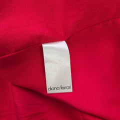Close-up of a red fabric with a silver label featuring 'diana fernan'.