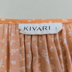 Close-up of an orange floral fabric with a 'KIVARI' label.