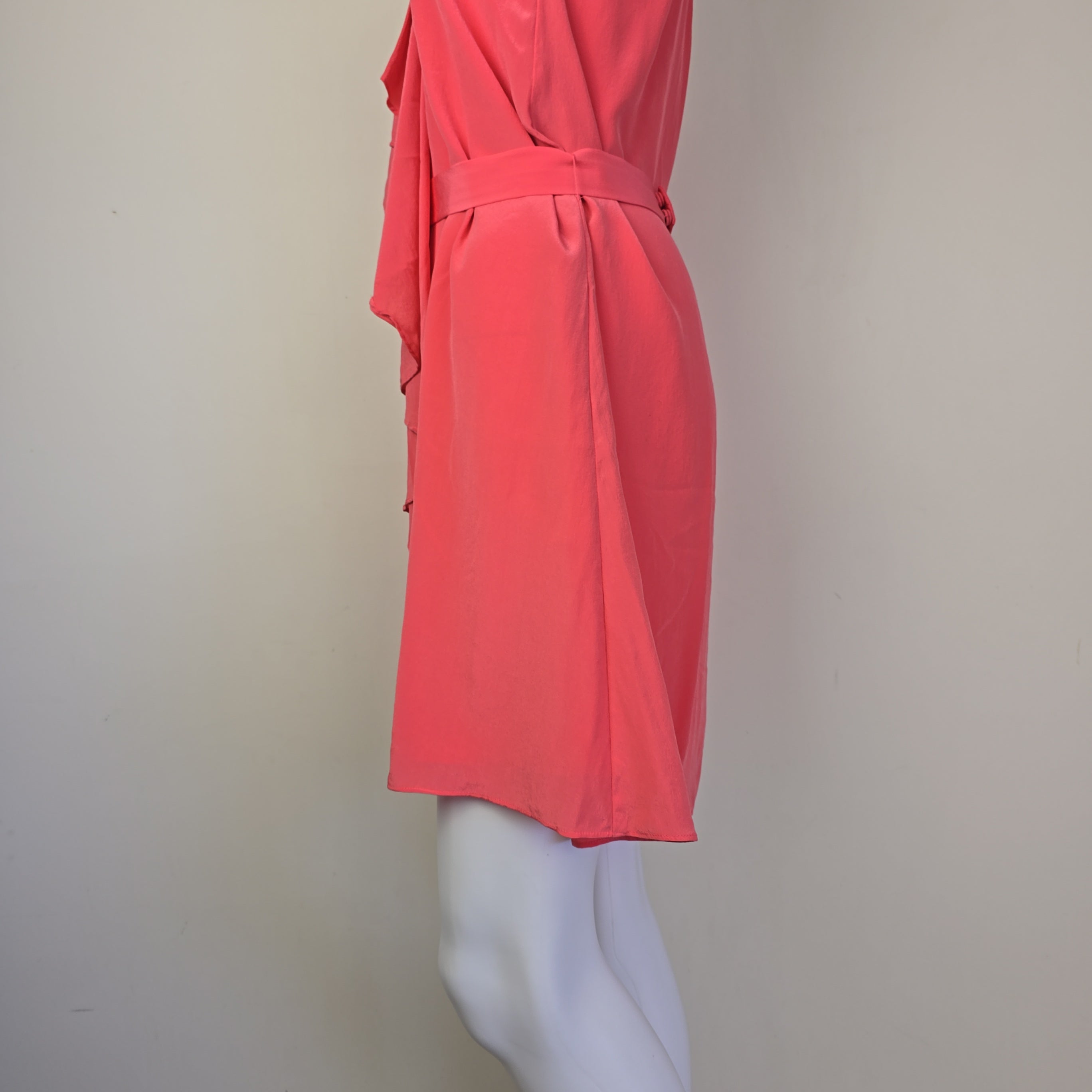 Pink dress on a mannequin against a plain background